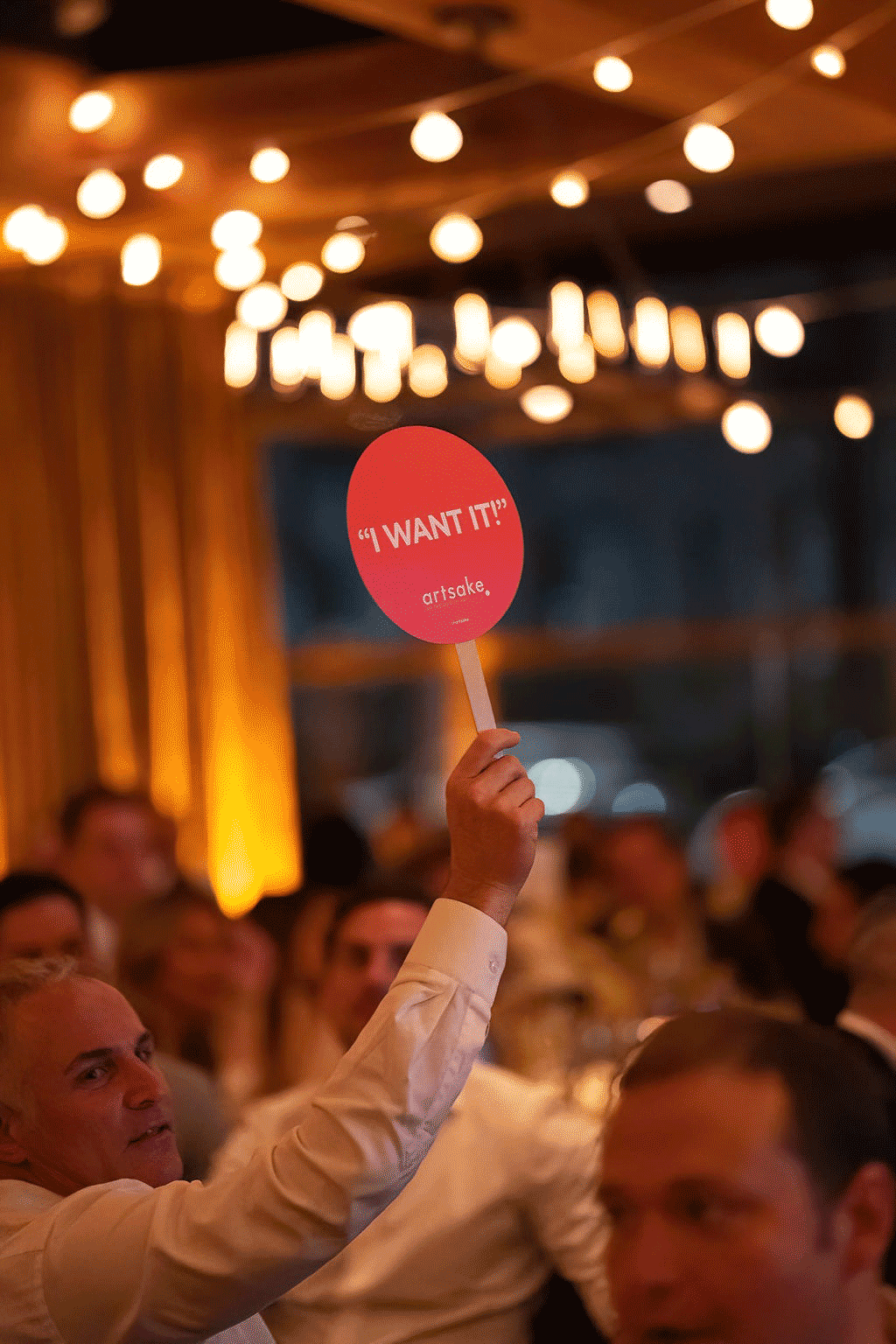 Guest holding auction paddle